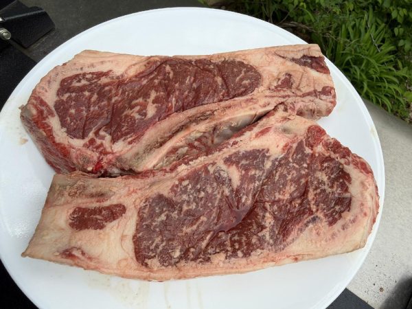 Two raw grain-finished ribeye steaks from Nadig Farms, showing rich marbling