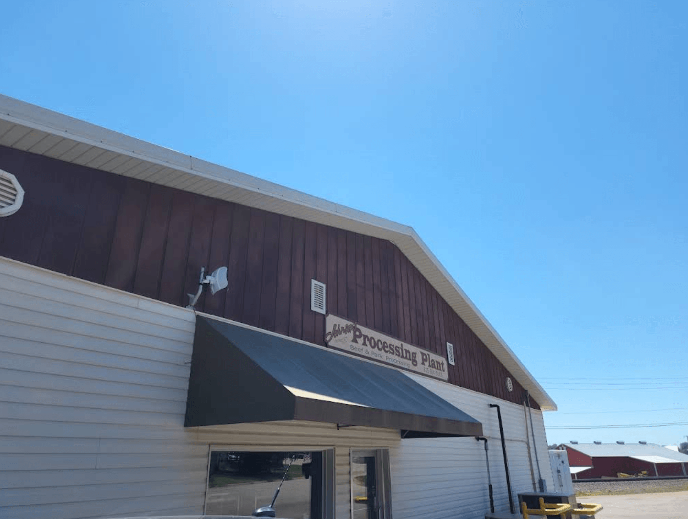 Exterior sign reading "Johnson's Processing Plant, Beef & Pork Processing" on the building at 201 IL Route 40 in Chadwick, Illinois.